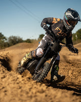 Rider cornering on a Talaria X3 Mini on a dirt track