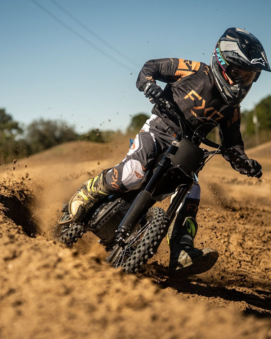 Rider cornering on a Talaria X3 Mini on a dirt track