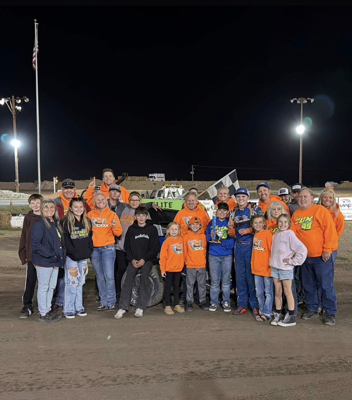 Victory lane at the dirt oval, with the trophy and checkered flag