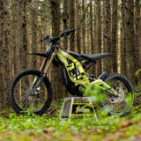 Sur-Ron Light Bee X in Green on a stand on a forest trail